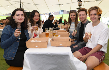 students sat at a table with drinks and picnic